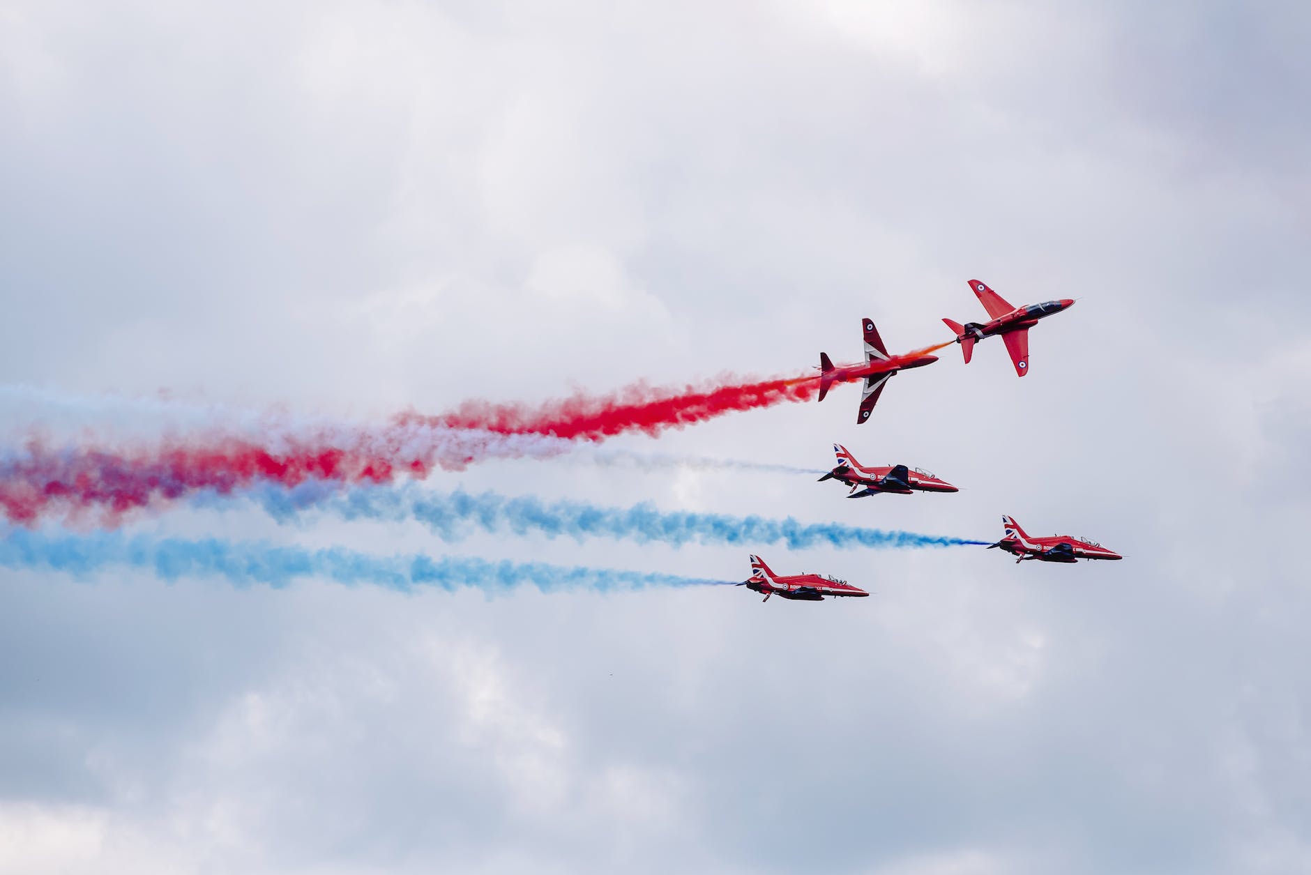 aerobatics performing by modern military aircraft in cloudy sky