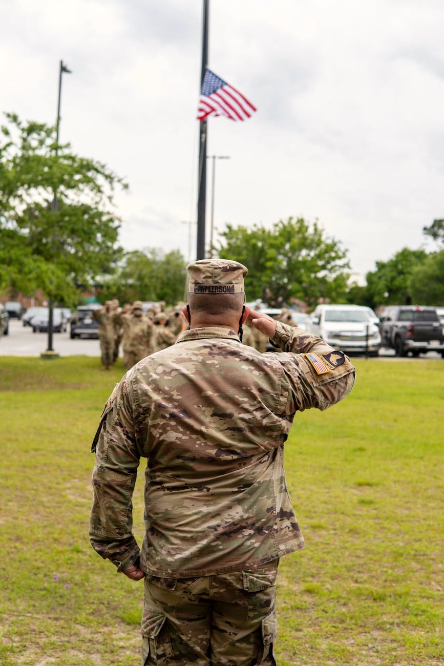soldier saluting flag flown at half mast