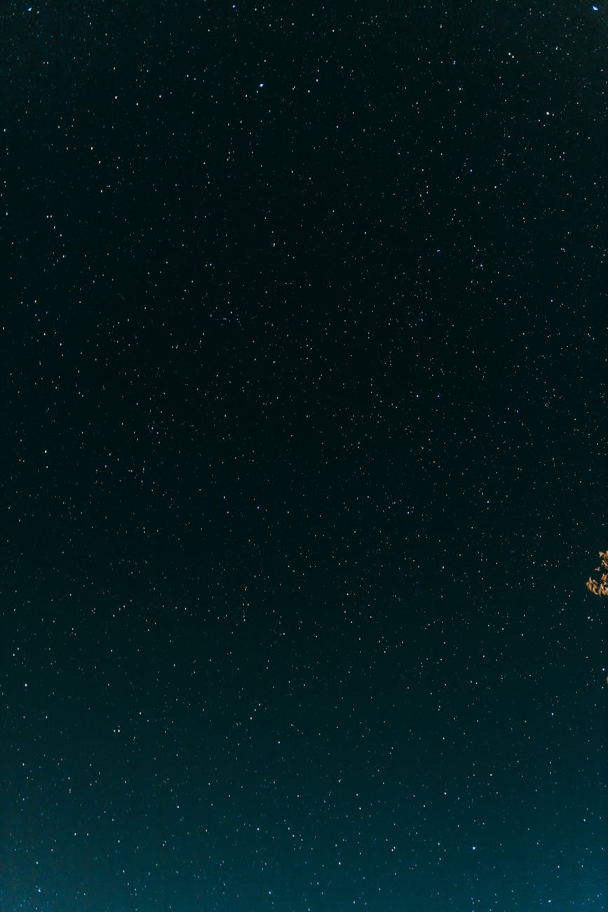 a starry night sky with a moon in the background