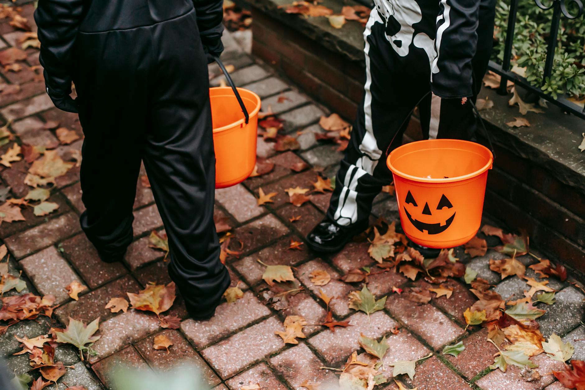 faceless kids in halloween costumes standing on walkway
