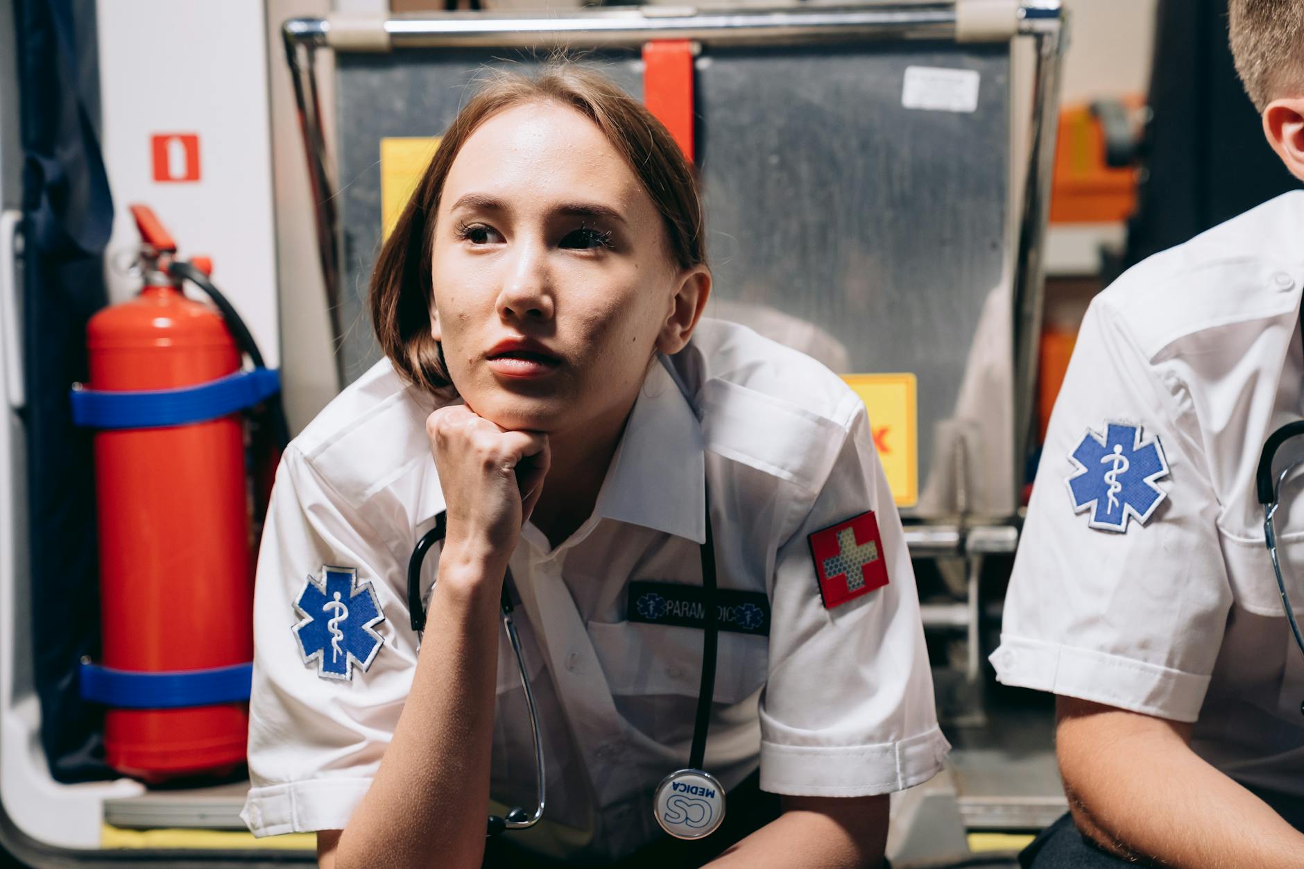 a paramedic sitting at the back of an ambulance