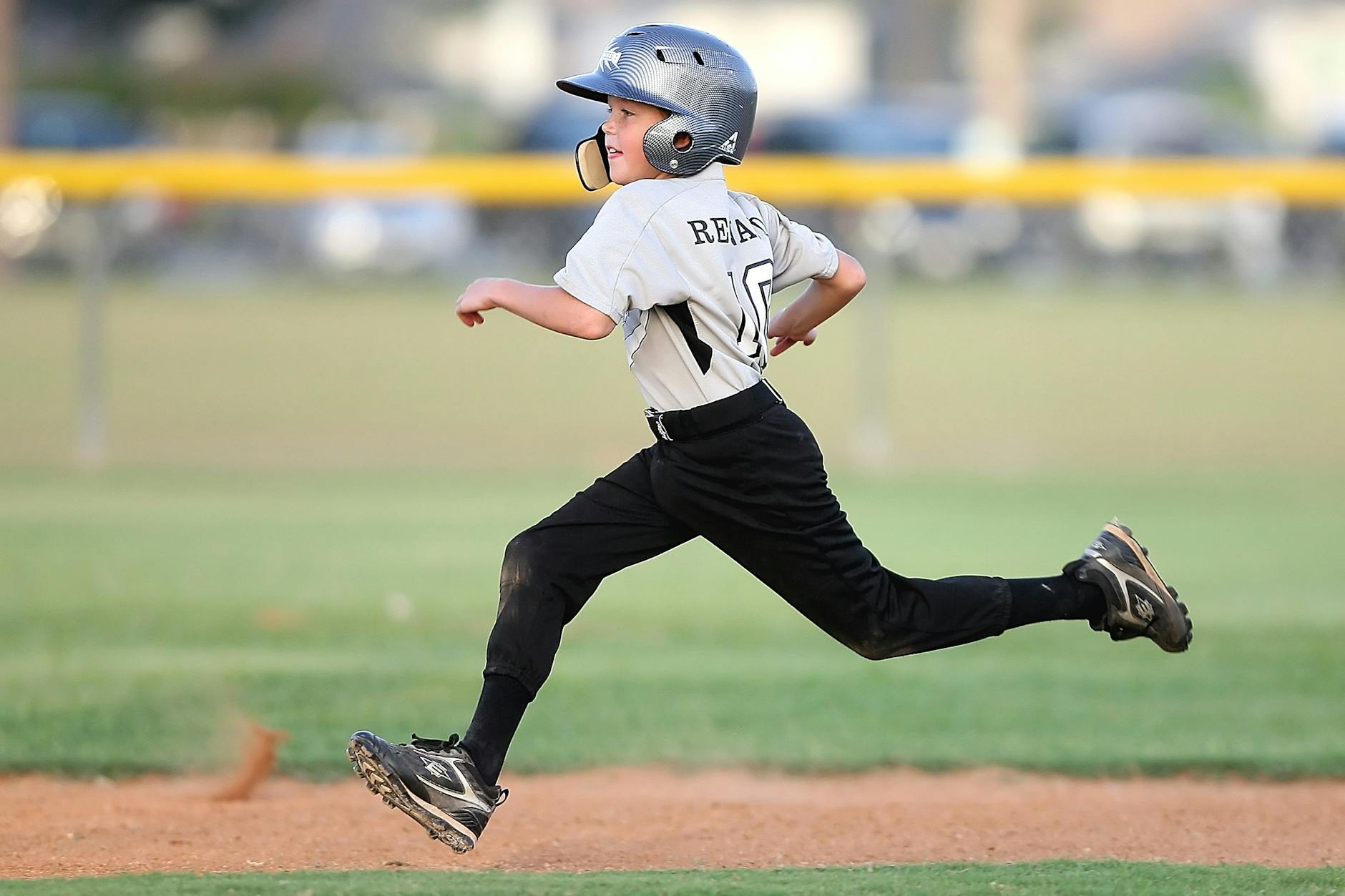baseball player in gray and black uniform running
